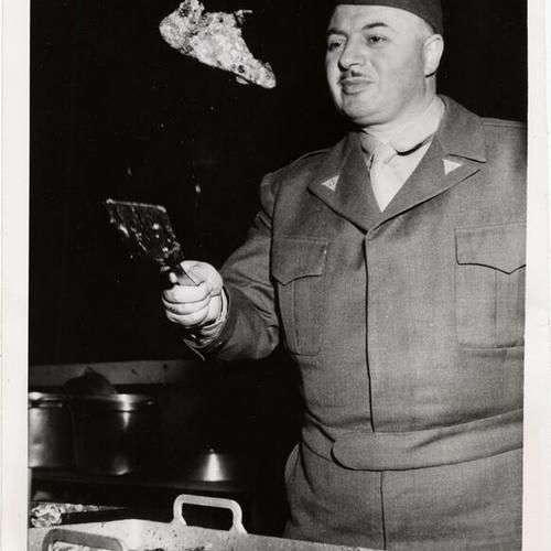 [George Mardikian demonstrating the proper way to cook pork chops]