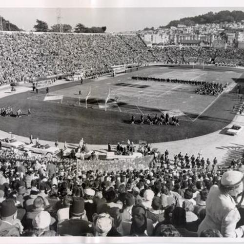 [Crowd watching the pre-game show at a football game at Kezar Stadium]