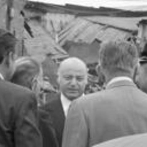 [Mayor Joseph Alioto and others, demolished building in background,