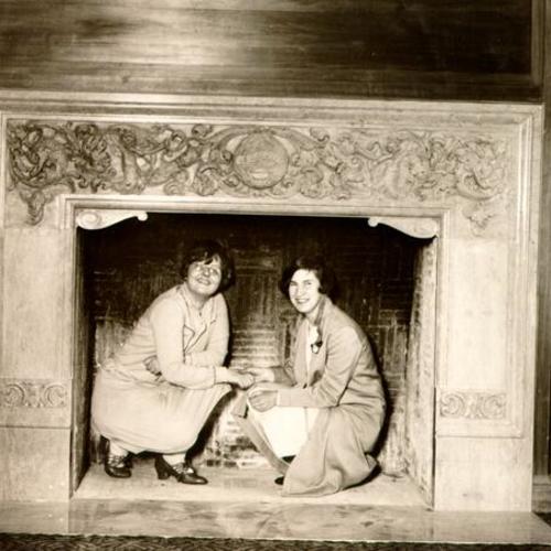 [Two women sitting under a fireplace at the Women's Building]