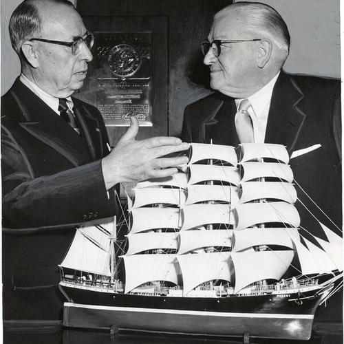 [Mayor Elmer Robinson and Hugh Gallagher examining a model of an old sailing ship]