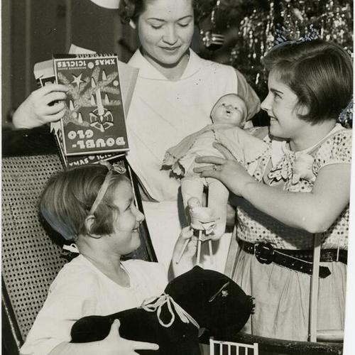 [Nurse Barbara Stevenson with patients Jebe and Loraine Turner during a Christmas party at Children's Hospital]