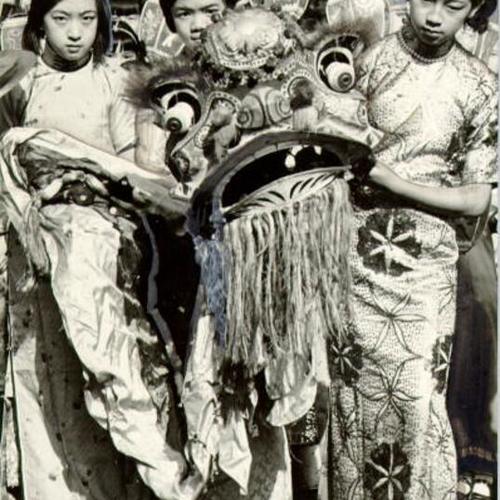 [Katherine Yeo, Lucy Tong and Phyllis Joro carrying a lions head at the Chinese New Years Festival]