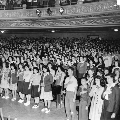 [Students giving pledge of allegiance in auditorium at Mission High School]