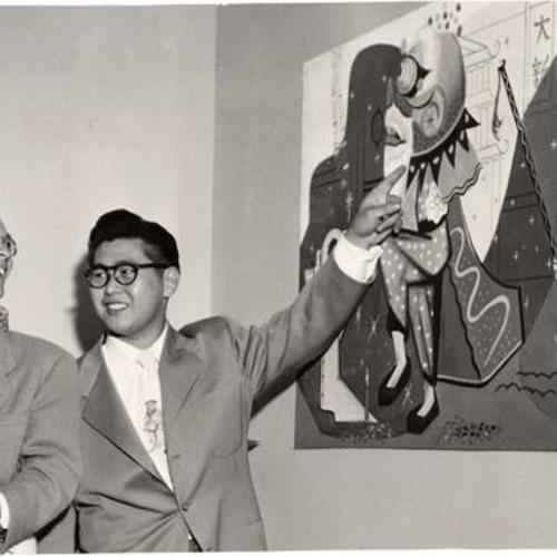 [Artist James C. Leong pointing to one of his murals in a model apartment at the Ping Yuen housing project]