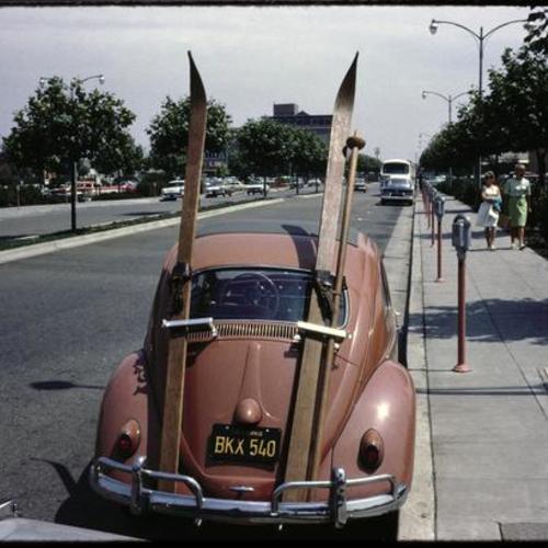 Volkswagen Beetle with skies parked on street