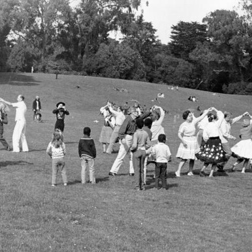 [People dancing on a field during the Golden Gate Park Centennial Parade]