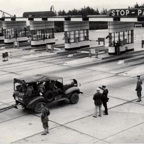 [Army truck from Fort Lewis, Washington, towing light artillery toward Golden Gate Bridge toll plaza]