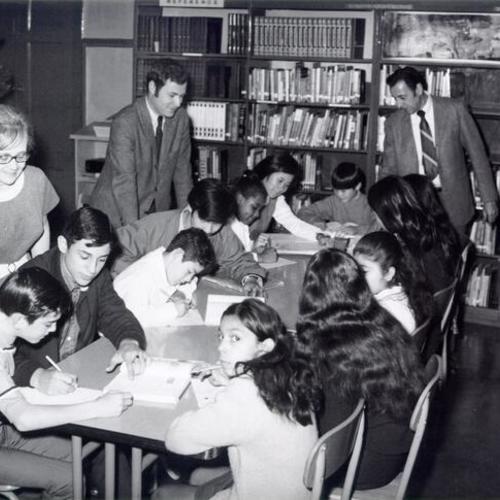 [Visitors visiting students in library at Sherman School]