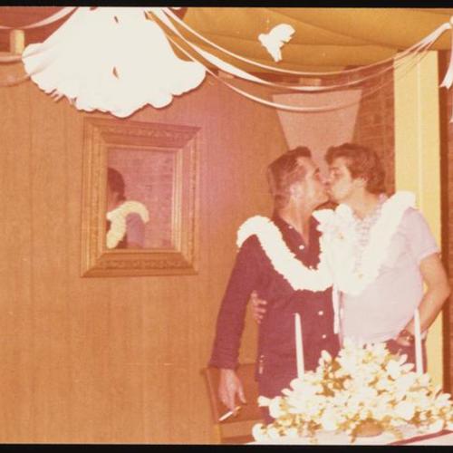 Two people kissing at Jim and Ken's wedding party