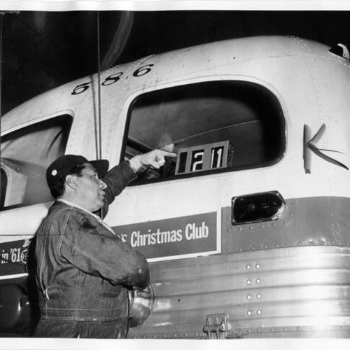 [Mechanic Cres Martinez checking route number on Municipal Railway trackless trolley car number 586]