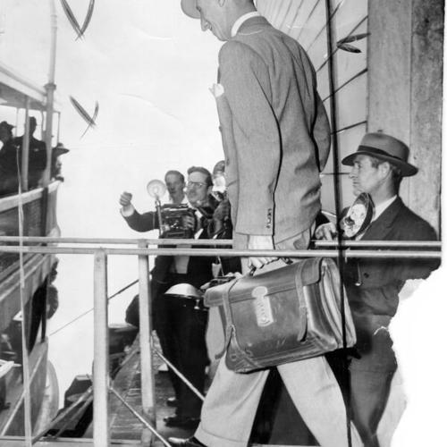 [Harry Bridges on gangplank of Angel Island boat with briefcase]