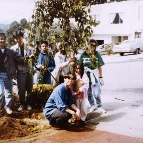 [Young adults planting trees on Ralston Street with Betty whose family was one of the first living in this neighborhood]