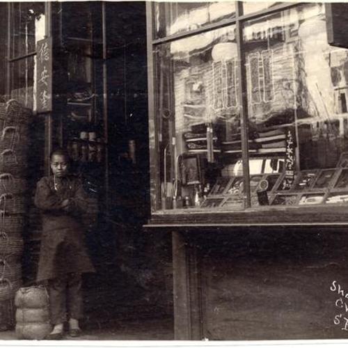 [Young man standing outside of a shop in Chinatown]