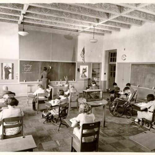 [Students and teacher in a classroom at Sunshine Orthopedic School]