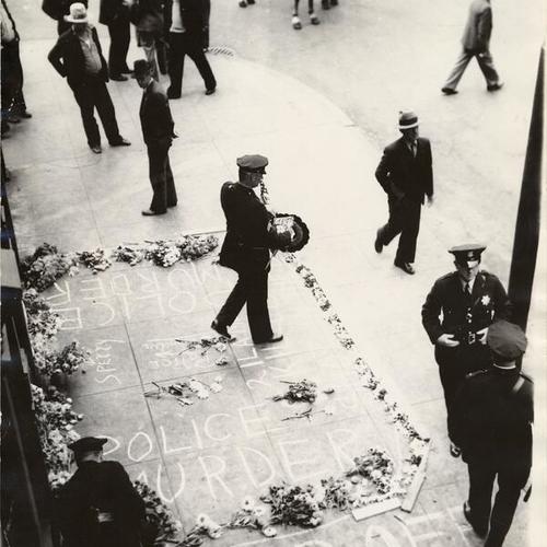 [Four policemen standing at the spot of a memorial on Mission Street for two men killed during longshoremen s strike]