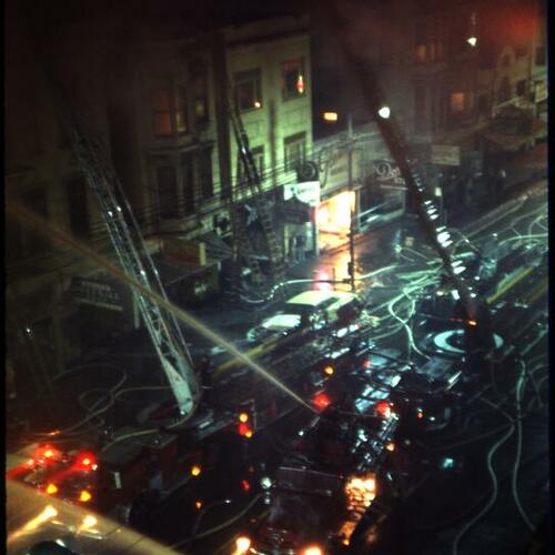 [Aerial view of firetrucks on street as they battle fire at night on Mission Street]