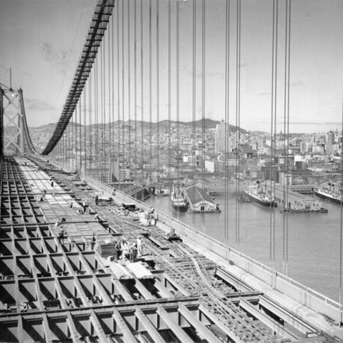 [Workers lay decking on San Francisco span of Bay Bridge]