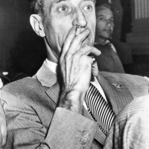 [Harry Bridges puffing on a cigarette just before taking the witness stand before the House Committee on UnAmerican Activities]