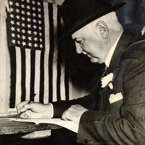 [Mayor Angelo J. Rossi signing the voting register at his polling place]