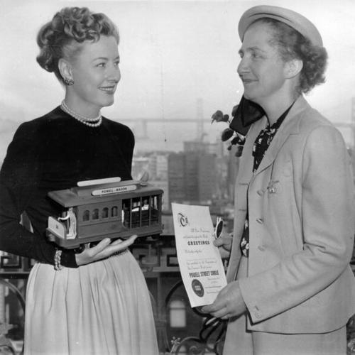 [Irene Dunne receiving a certificate from Mrs. Hans Klussmann in recognition of her contribution to the "Save the Cable Cars" campaign]