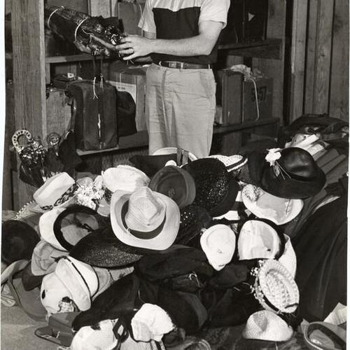 [John Brady posing with items left by passengers on Southern Pacific trains]