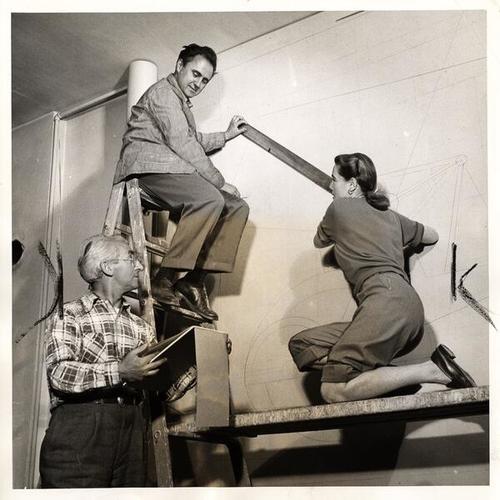 [Artists George Harris (atop ladder), Luke Gibney and assistant Margaret Davis working on the mural in the foyer of the San Francisco Chamber of Commerce]