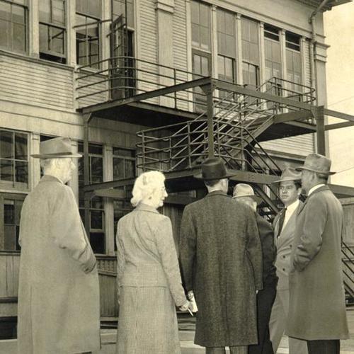 [Superintendent Herbert C. Clish showing opponents of a school bond measure an unsafe fire escape at Douglas School]