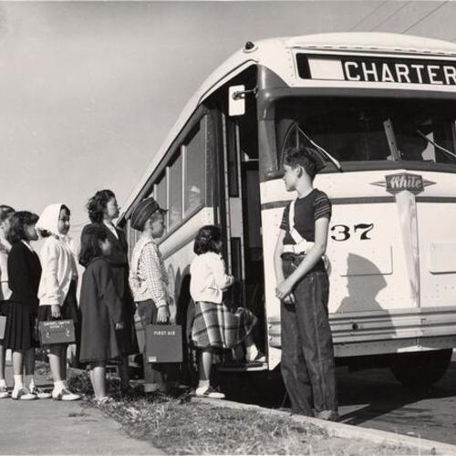 [Kids boarding a bus]