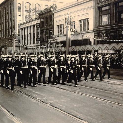[Marching servicemen passing by spectators in the opening day celebration parade for San Francisco-Oakland Bay Bridge]