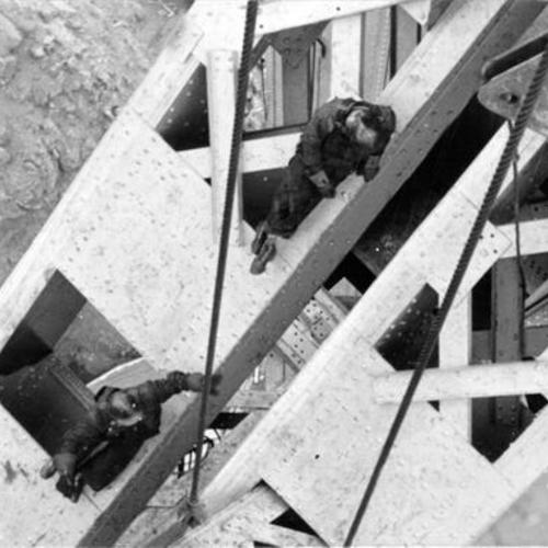 [Construction workers rivet sections of Golden Gate Bridge north tower]