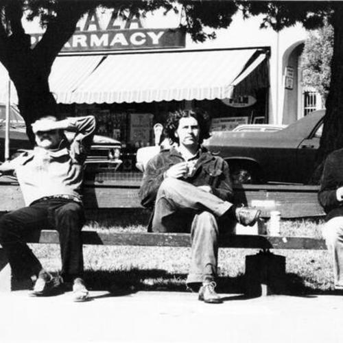 [Three people sitting on a bench on the north side of Washington Square Park in North Beach]