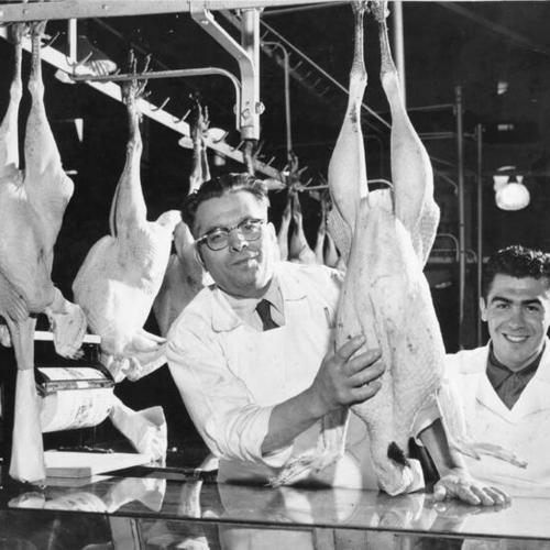 [Tony Zanca and his son and partner, Tony Jr., displaying a 35 pound turkey in the poultry department of the Crystal Palace Market]
