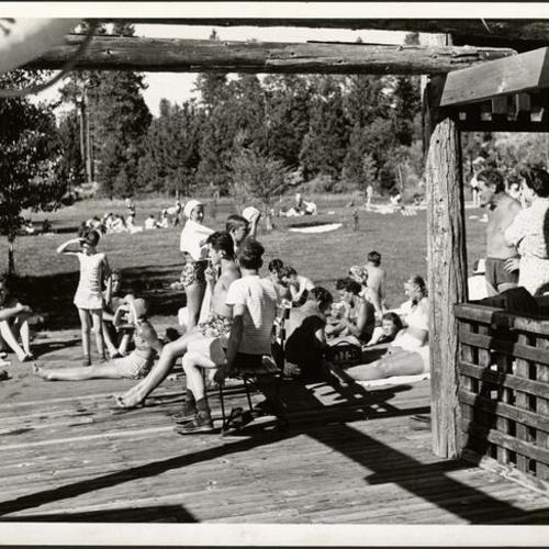 [Campers relaxing near lake at Camp Mather]