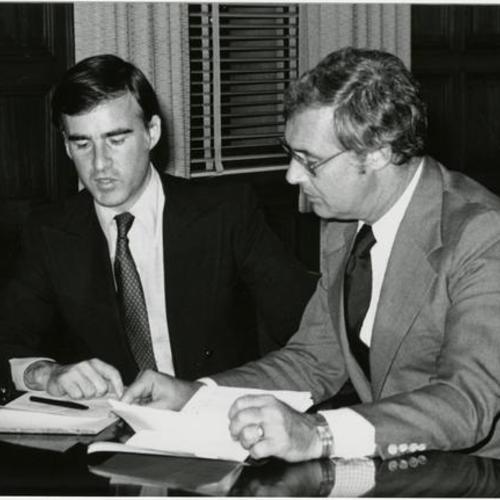 [Governor Jerry Brown and Mayor George Moscone reading papers]