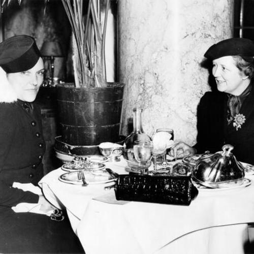 [Mrs. Joseph C. Hickingbotham and Mrs. Charles Sweet having lunch in the Palm Court of the Palace Hotel]