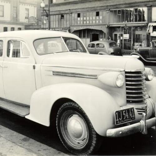 [Closeup of 1937 Oldsmobile parked on Kearny Street near Jackson]