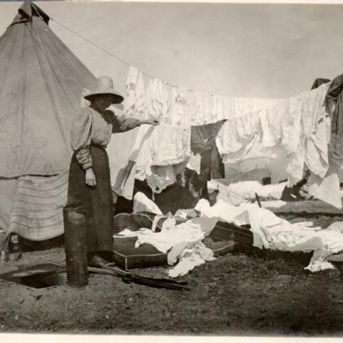 [Woman  washing and drying clothes at a refugee camp]