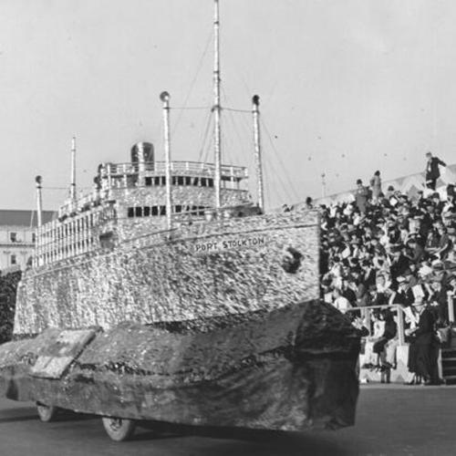 [Float, titled "Port Stockton", passing by spectators in the opening day celebration parade for San Francisco-Oakland Bay Bridge]