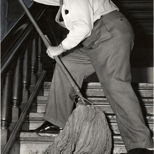 [Barney Gould swabbing a staircase inside the riverboat "Fort Sutter"]