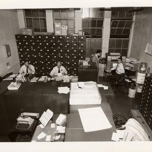 [Employees working in crowded office in Old Hall of Justice]
