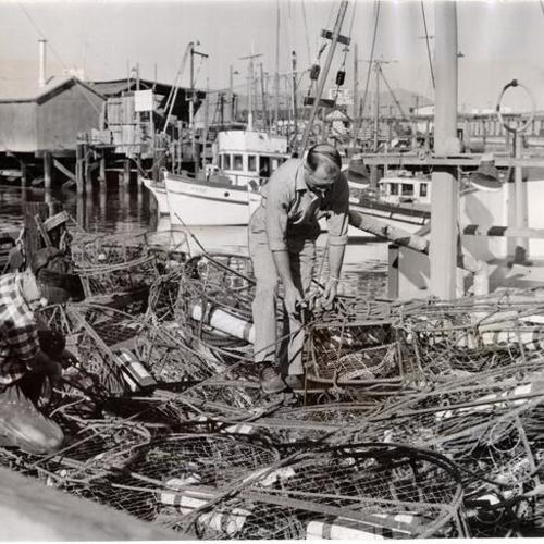 [B. Bellante and C. Crivelo giving their crab pots a final check before they leave Fisherman's Wharf]