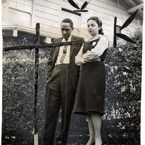 [Assistant District Attorney Cecil Poole and his wife looking at a cross burned on lawn of his Ingleside Terrace home]
