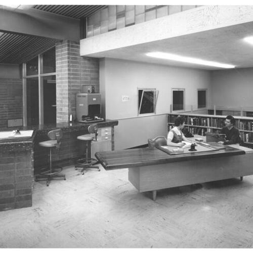 [Two library workers inside Marina Branch Library]