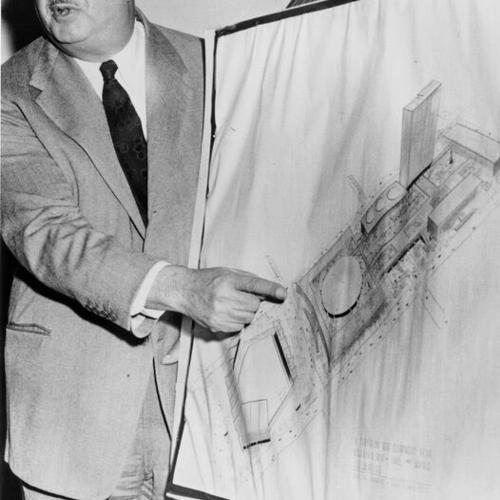 [Benjamin H. Swig, hotelman and financier, pointing at sketch of plan for redevelopment of downtown city blocks]