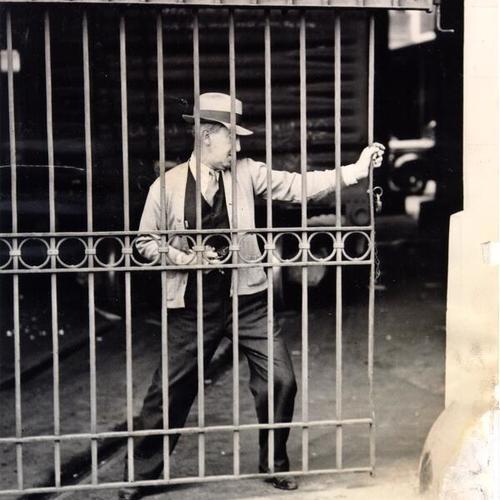 [J. W. Rick closing the gate of a warehouse]
