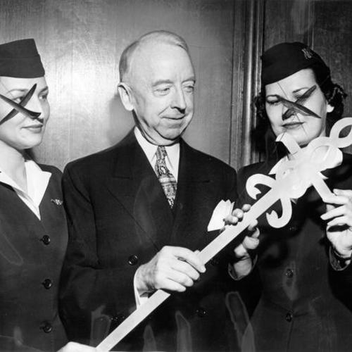 [Thomas A. Brooks is presented with a hand-hewn aluminum sword, the insignia of the American Cancer Society]