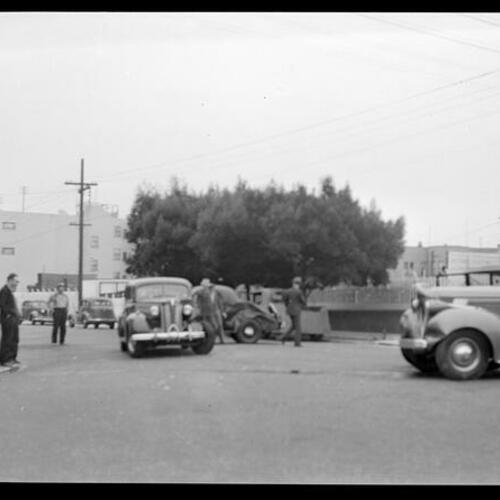 [A group of people look at a car accident at the intersection of Baker and Grove. ]