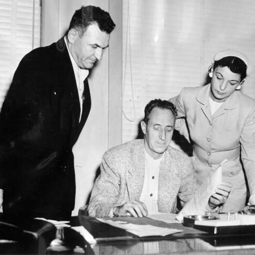 [Harry Bridges in his office with J.R. Robertson and Mrs. Nancy Bridges]