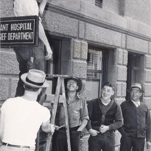 [W. D. Wightman putting up a sign calling for machinists to register for work at the Bethlehem Shipbuilding Corporation plant in San Francisco]